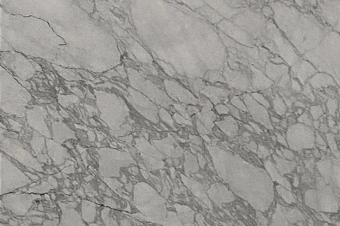 Photograph: a band of grey breccia-like veining across the sawn face of a squared white block at the quarry.